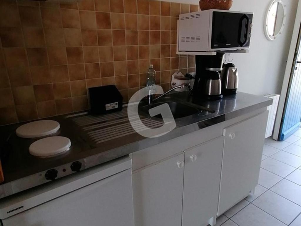 a kitchen counter with a coffee maker and a microwave at Appartement La Tranche-sur-Mer, 3 pièces, 5 personnes - FR-1-357-309 in La Tranche-sur-Mer