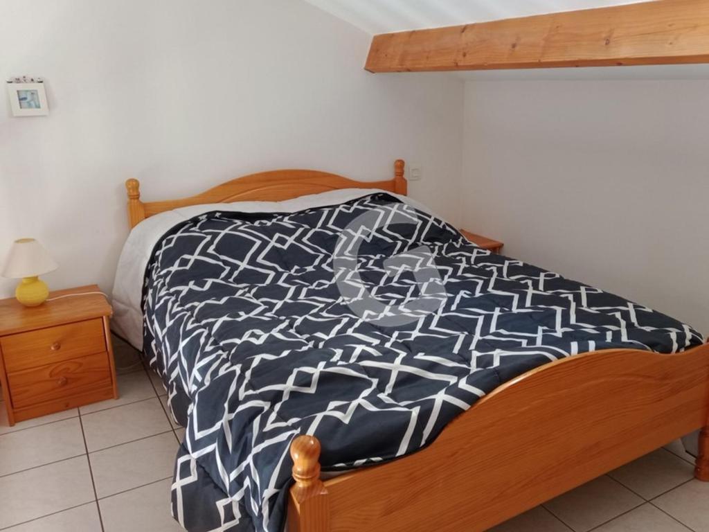 a bedroom with a bed with a black and white bedspread at Appartement La Tranche-sur-Mer, 3 pièces, 5 personnes - FR-1-357-309 in La Tranche-sur-Mer