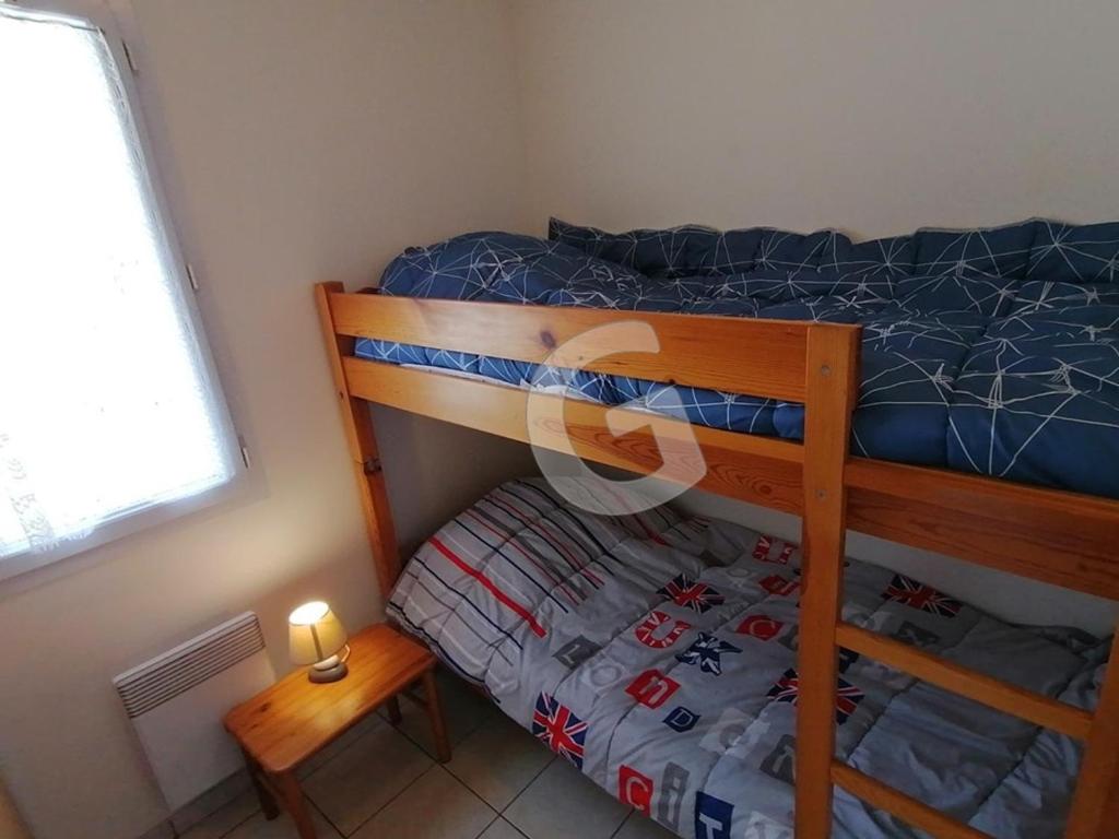 a bedroom with a bunk bed and a small table at Appartement La Tranche-sur-Mer, 3 pièces, 5 personnes - FR-1-357-309 in La Tranche-sur-Mer