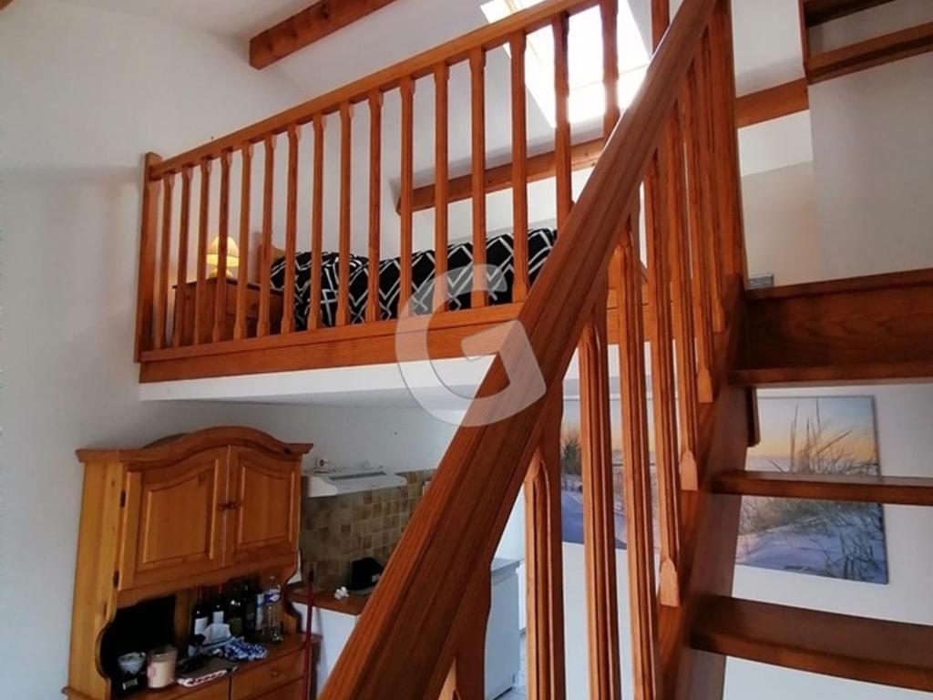 a wooden staircase in a room with a kitchen at Appartement La Tranche-sur-Mer, 3 pièces, 5 personnes - FR-1-357-309 in La Tranche-sur-Mer