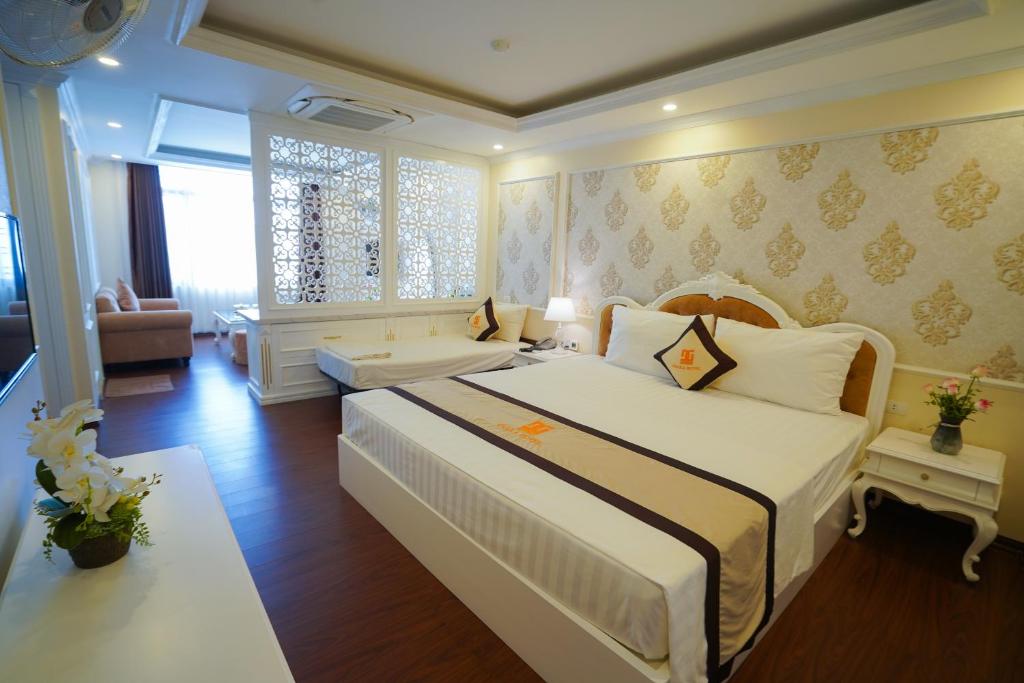 a bedroom with a large bed and a living room at Osaka Ha Long Hotel in Ha Long