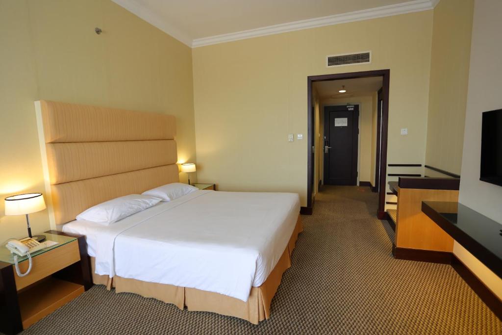 Postel nebo postele na pokoji v ubytování Dynasty Hotel Miri
