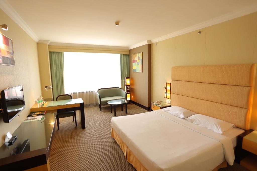 Postel nebo postele na pokoji v ubytování Dynasty Hotel Miri