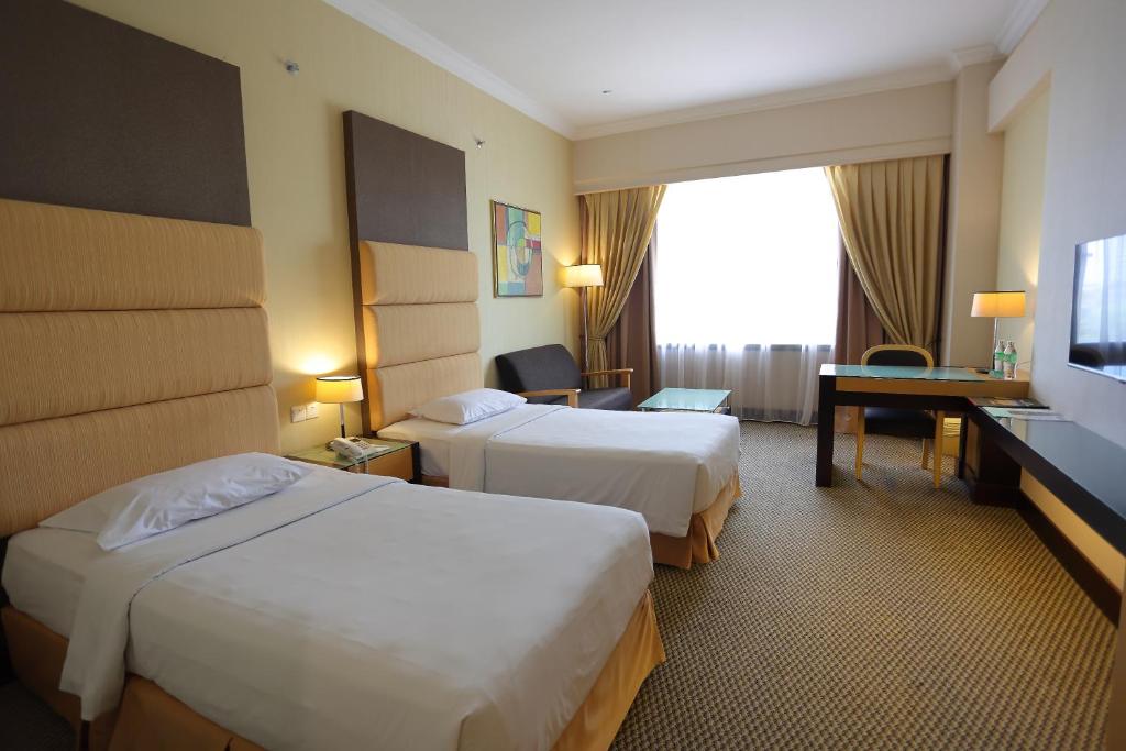 Postel nebo postele na pokoji v ubytování Dynasty Hotel Miri