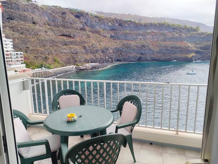 einen Tisch und Stühle auf einem Balkon mit Meerblick in der Unterkunft Apartamento a pie de playa en San Marcos in San Marcos