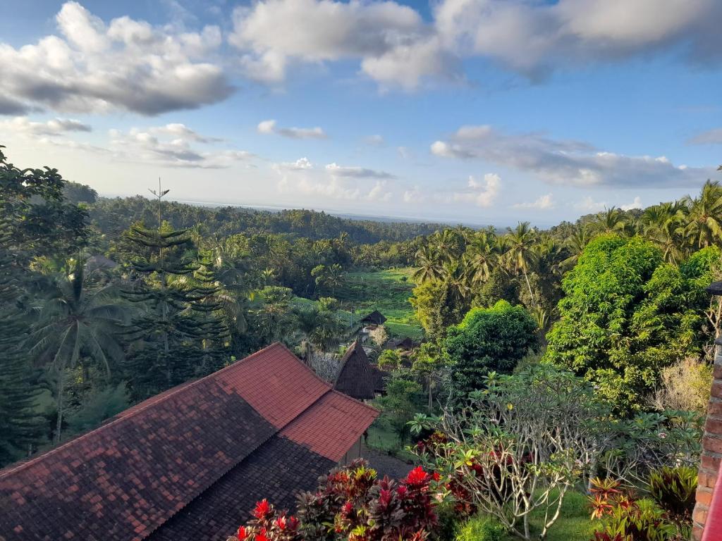 a person standing on top of a house in a forest at Kebun Villa, Belimbing, Bali in Tabanan