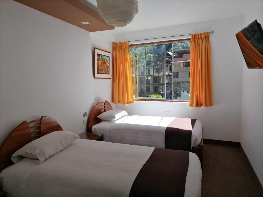 Habitación de hotel con 2 camas y ventana en Hostal Premier Inn, en Machu Picchu