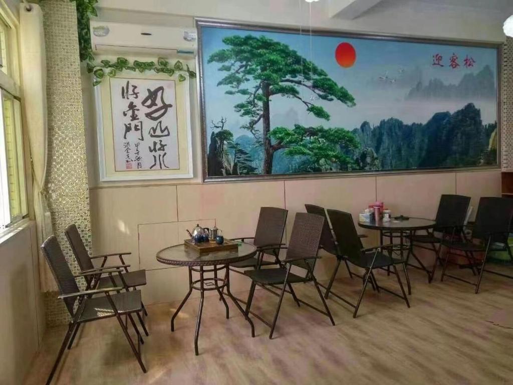 a restaurant with tables and chairs and a large painting on the wall at 好金門民宿 in Jincheng