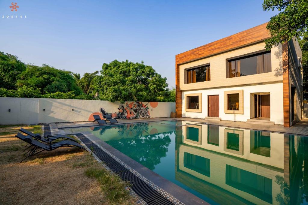 a swimming pool in front of a house at Zostel Jim Corbett in Rāmnagar