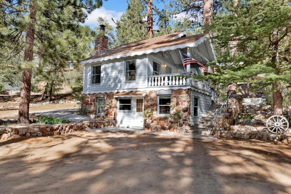 an old stone house with an american flag on it at Pinglewood Cabin- Furnished Fawnskin Group Retreat in Fawnskin