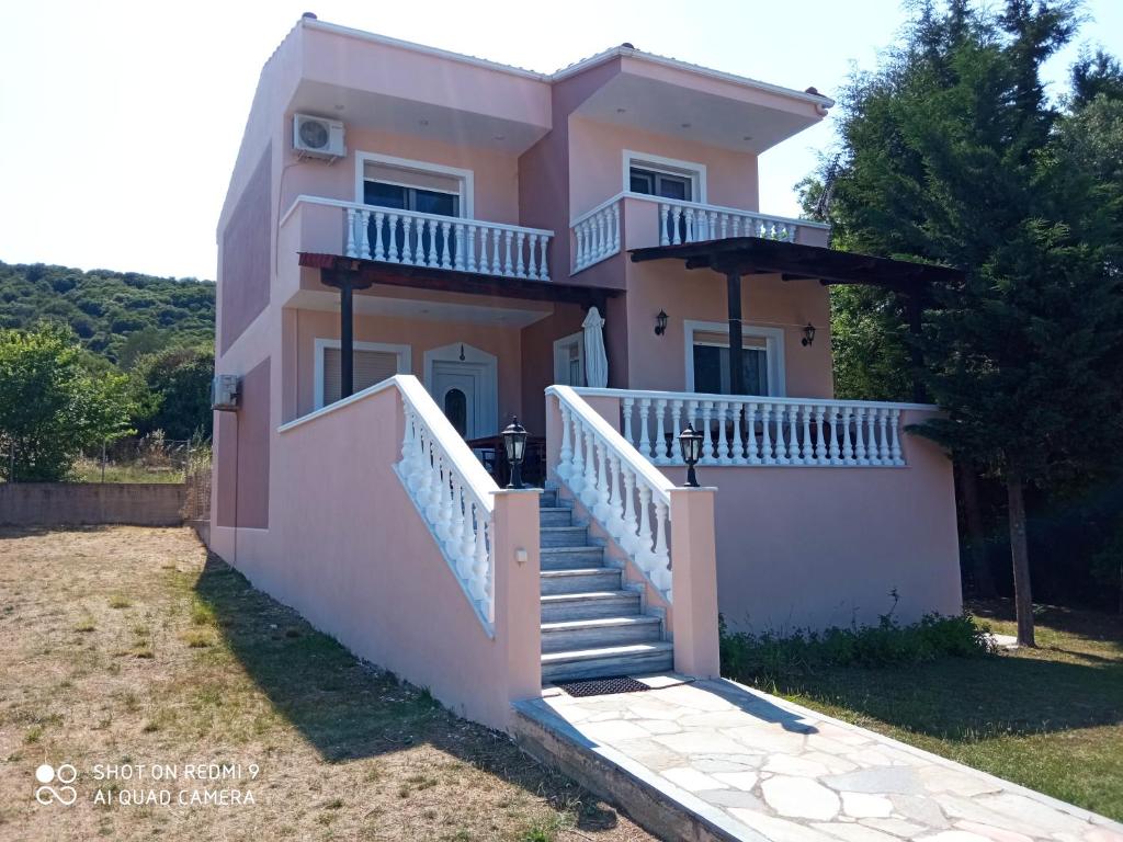 a pink house with stairs in front of it at VILLA TASOS in Iraklitsa