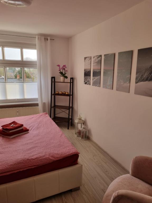 Katzow的住宿－Storchenhof Engel，一间卧室配有红色的床和椅子