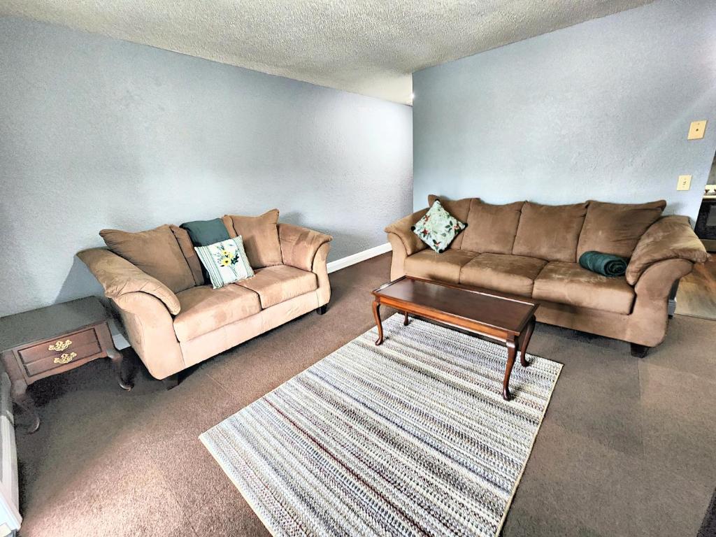 Sala de estar con 2 sofás y mesa de centro en Cute and Comfy with porch, en Lakeland