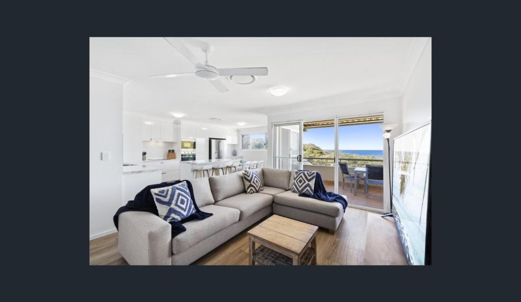 a living room with a couch and a table and a kitchen at Samarinda Jewel by the Sea in Point Lookout