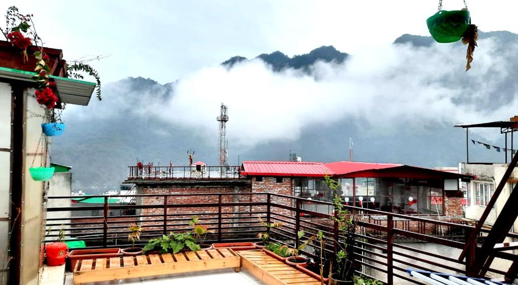 a building on a balcony with clouds in the background at Hotel The Mountain View in Rishīkesh