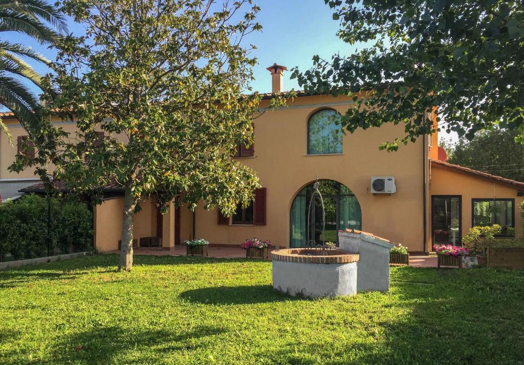 uma casa com uma árvore em frente em Il Casale Relais em San Giuliano Terme