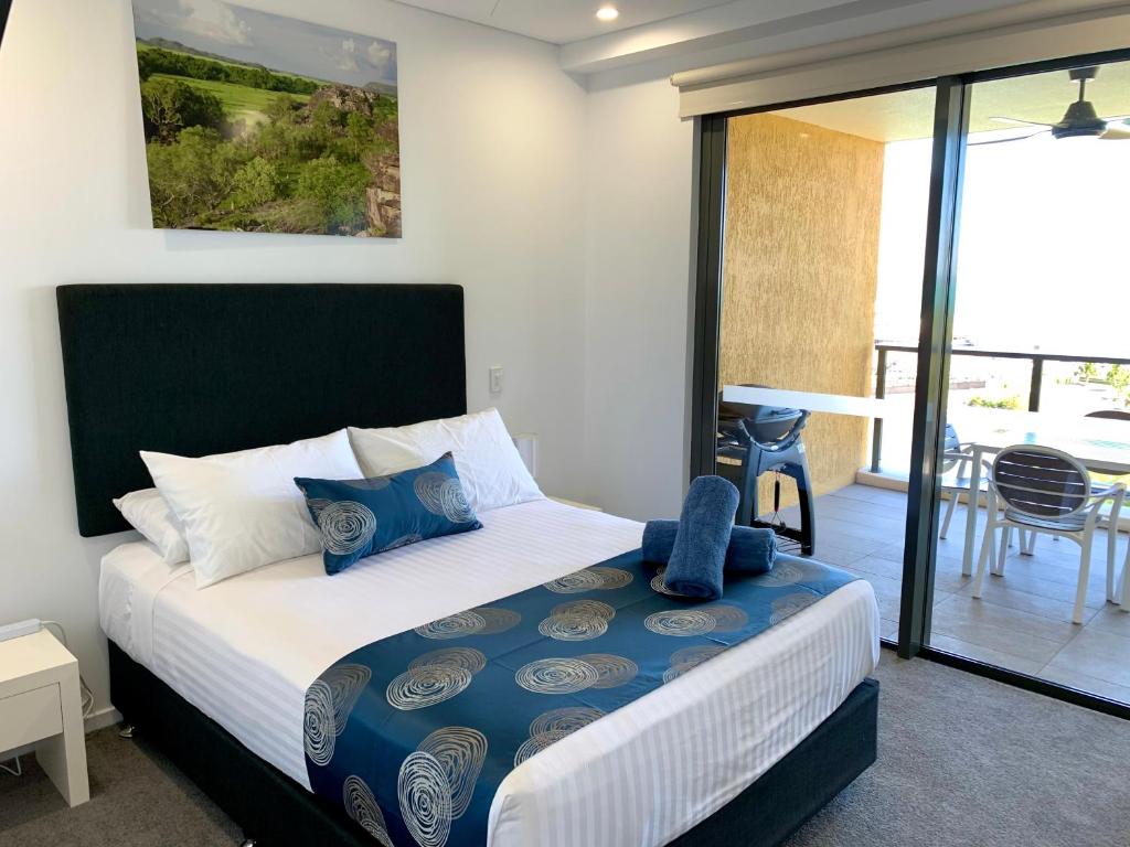 a bedroom with a bed and a balcony at Serenity Peary - Executive 1brm at Darwin Waterfront with Sea Views in Darwin