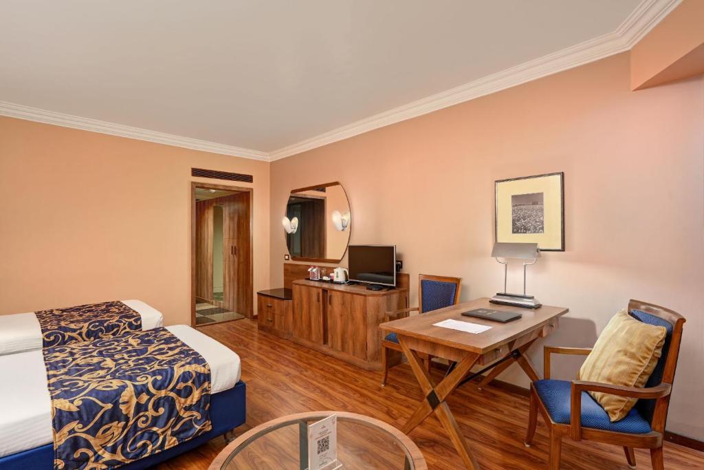 Postel nebo postele na pokoji v ubytování The Cama - A Sabarmati Riverfront Hotel