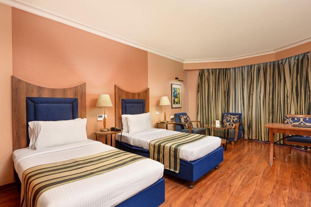 Postel nebo postele na pokoji v ubytování The Cama - A Sabarmati Riverfront Hotel