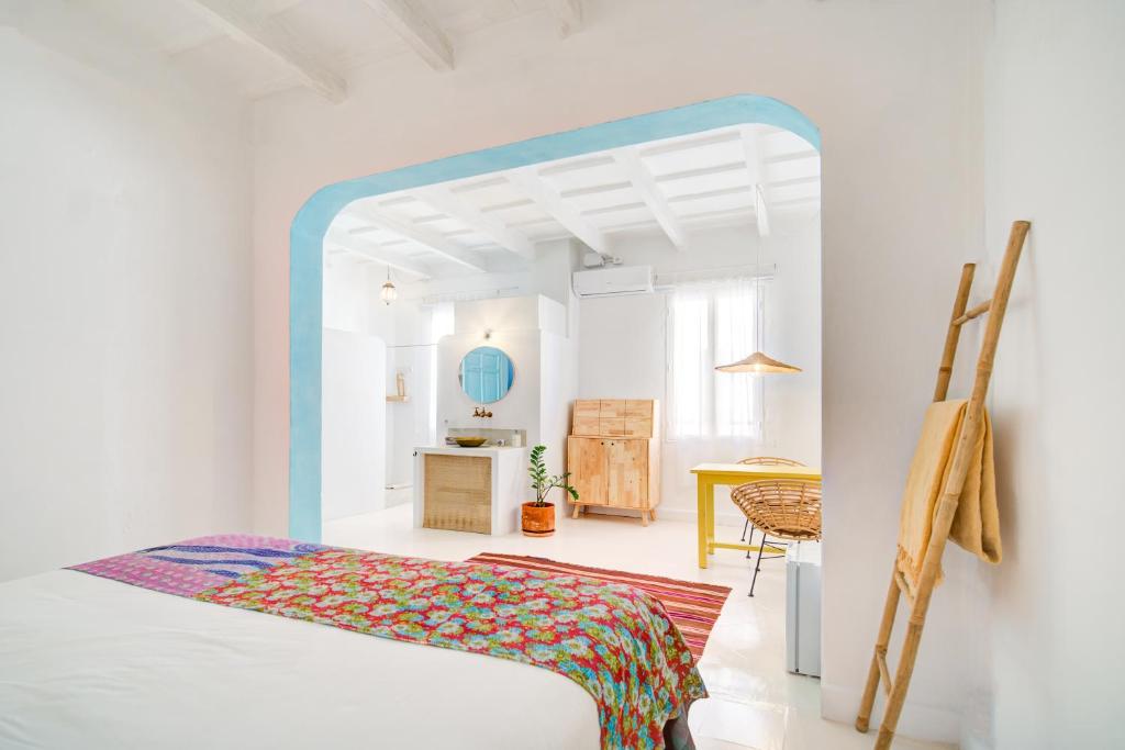 a white room with a bed and a table at La Cayena Rooms in Ciutadella