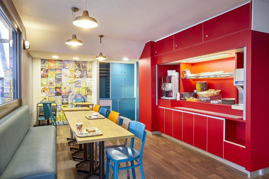 a restaurant with red walls and a table and chairs at hotelF1 Evreux Sud in Évreux