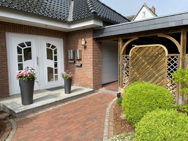a house with two potted plants on a brick driveway at Haus Antje in Scharbeutz