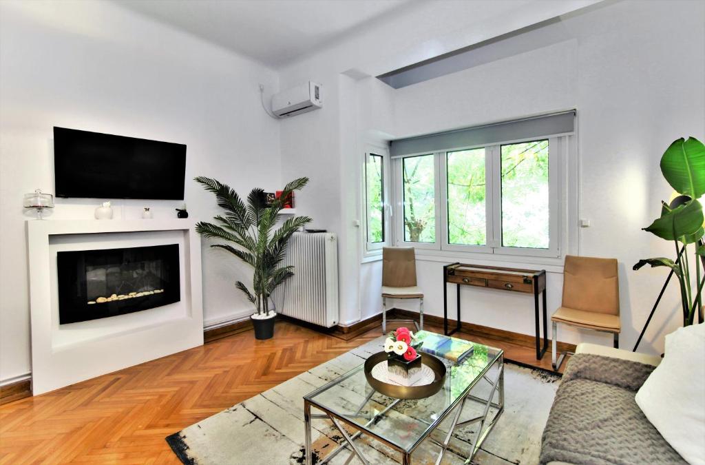 een woonkamer met een bank en een open haard bij Kolonaki Jewel 1st floor feel like home properties in Athene