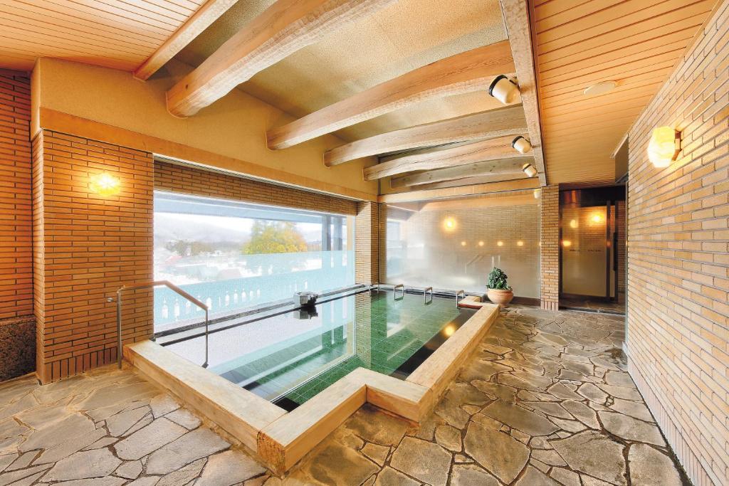 una piscina in una casa con una grande finestra di Sun Members Hirugano a Gujo