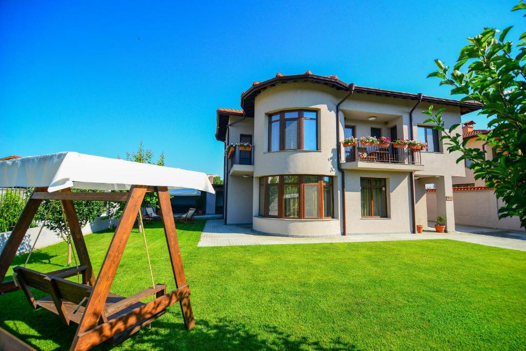 a house with a swing in front of a yard at KATERINA guest house in Kocherinovo