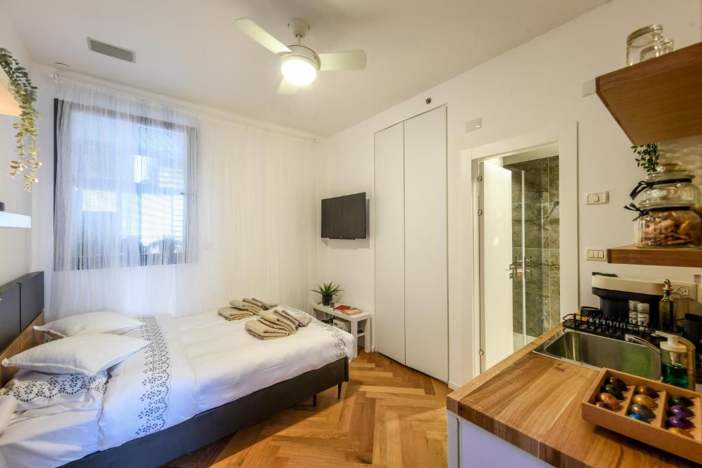 a bedroom with a bed and a kitchen with a sink at Stunning Modern Studio in Netanya minutes from the beach by Sea N' Rent in Netanya