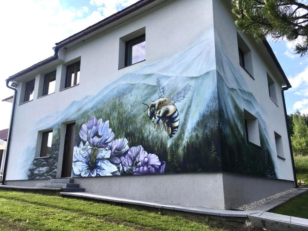 a mural of a bee on the side of a building at Chata Studnička Šumiac in Šumiac
