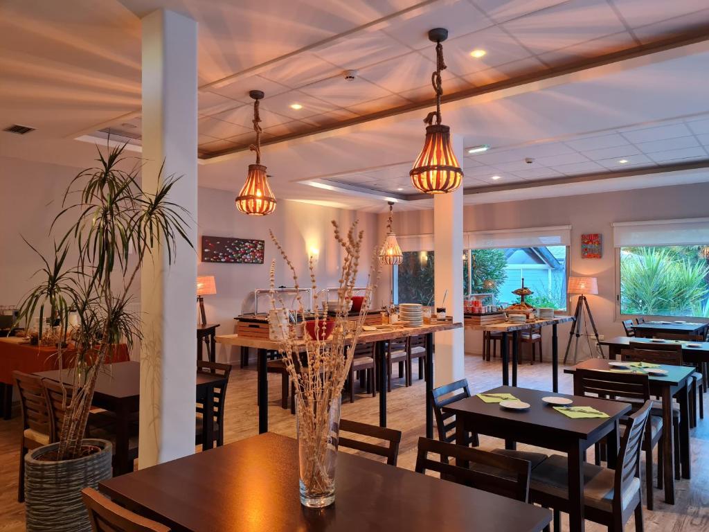 PloemelにあるHôtel du Golf Saint-Laurentのテーブル、椅子、照明付きのレストラン