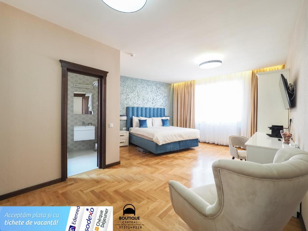 a bedroom with a bed and a chair in a room at Boutique Central in Sibiu
