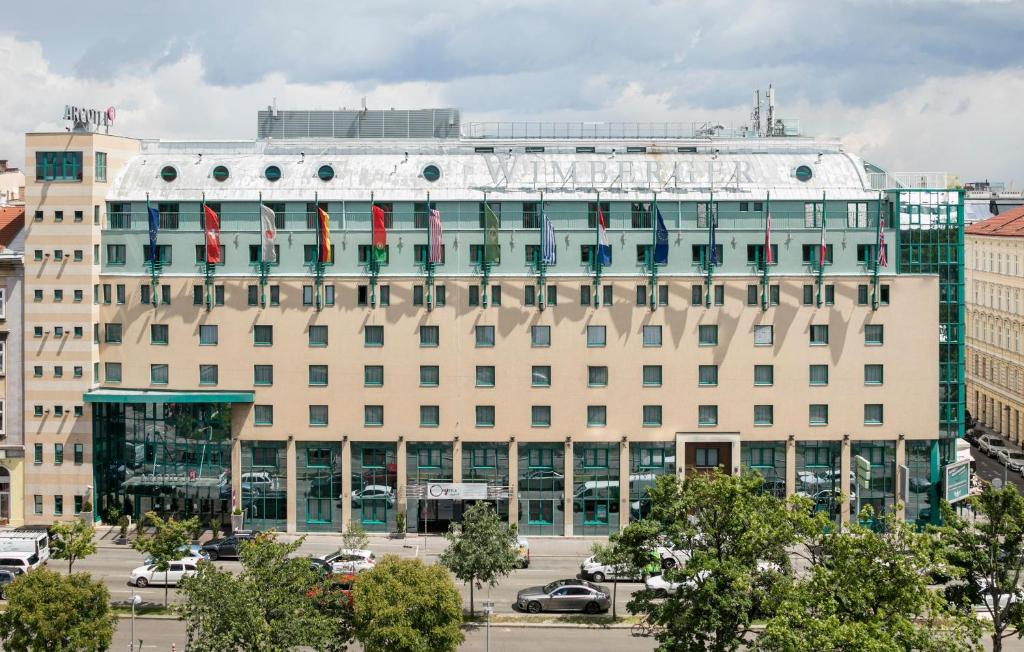 un gran edificio blanco con un cartel. en ARCOTEL Wimberger Wien, en Viena