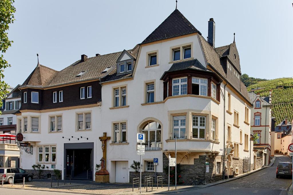 duży biały budynek po stronie ulicy w obiekcie Ferienwohnungen am Gestade w mieście Bernkastel-Kues