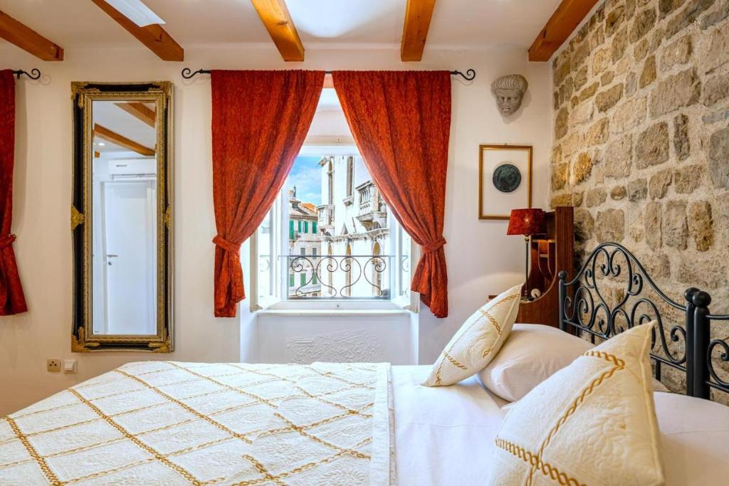 a bedroom with a bed and a window and a mirror at Luxe Villa Ammarulla in Split