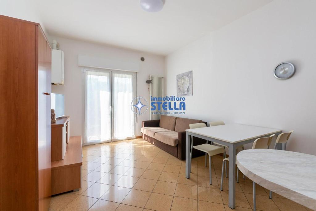 uma sala de estar com uma mesa e um sofá em Condominio Dalla Barbara em Lido di Jesolo