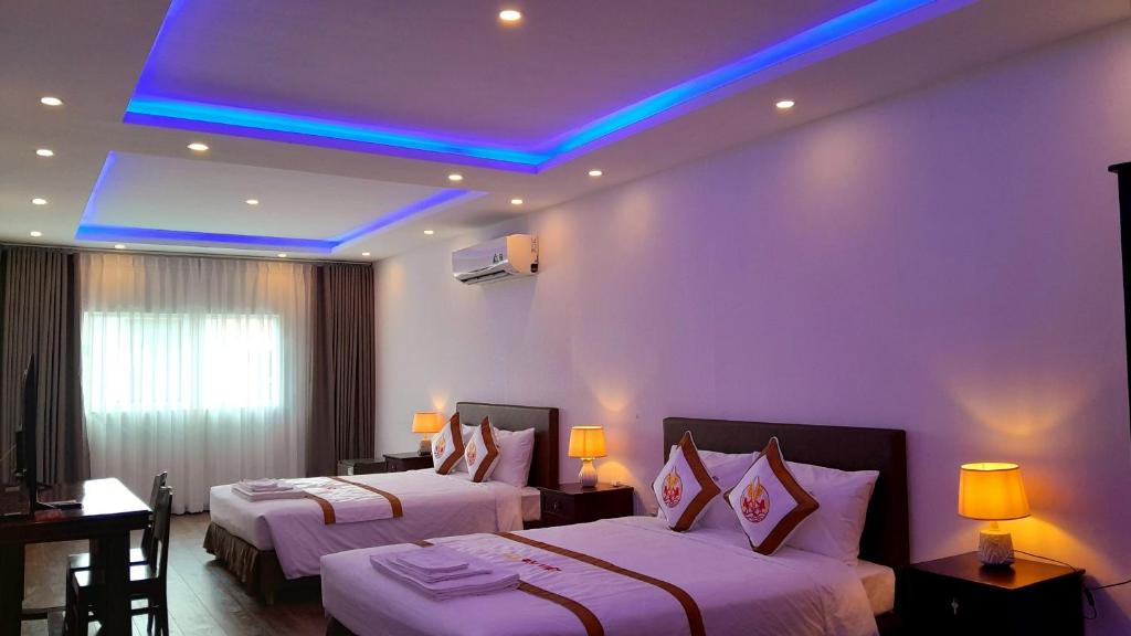 a hotel room with two beds and a blue ceiling at THE RICE HOTEL in Ho Chi Minh City