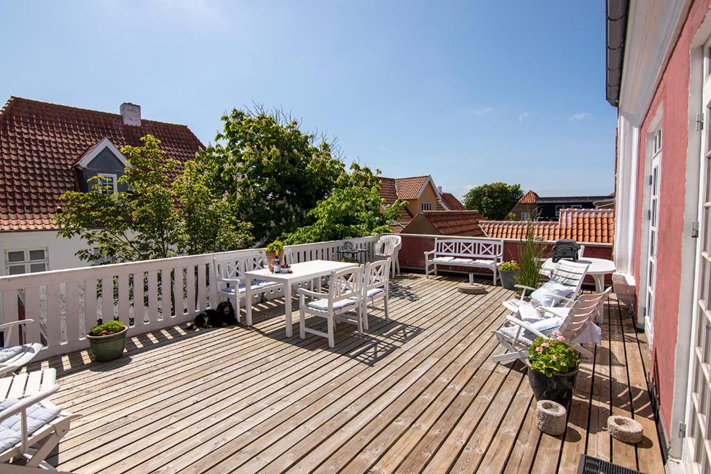 una terrazza in legno con tavolo e sedie. di BO GODT I SKAGEN.DK a Skagen