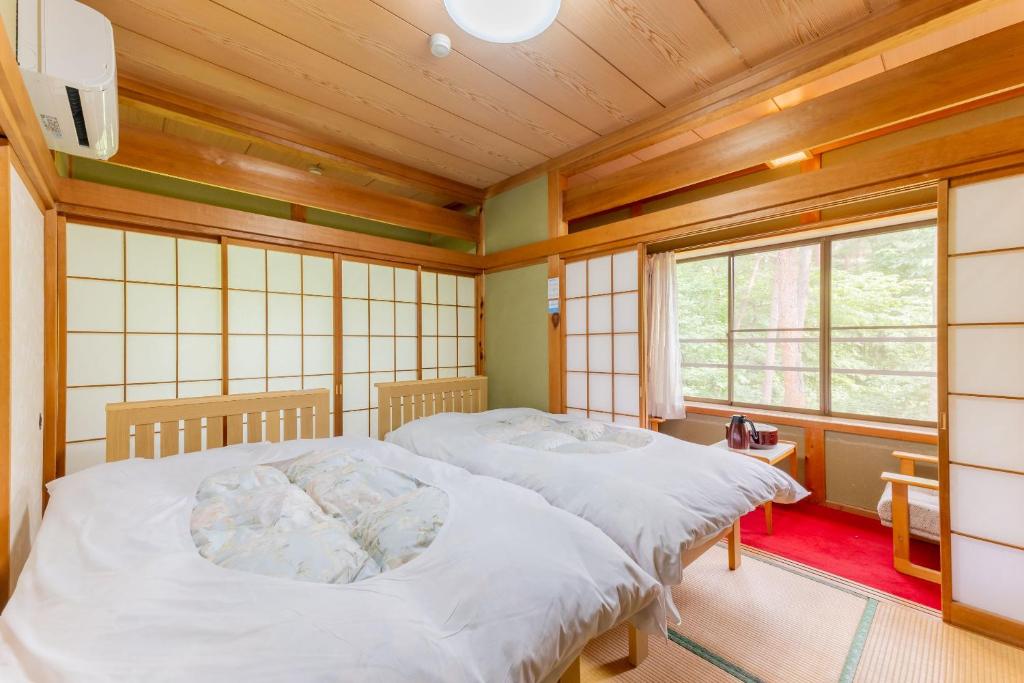 Postel nebo postele na pokoji v ubytování 檜湯の宿　松伯