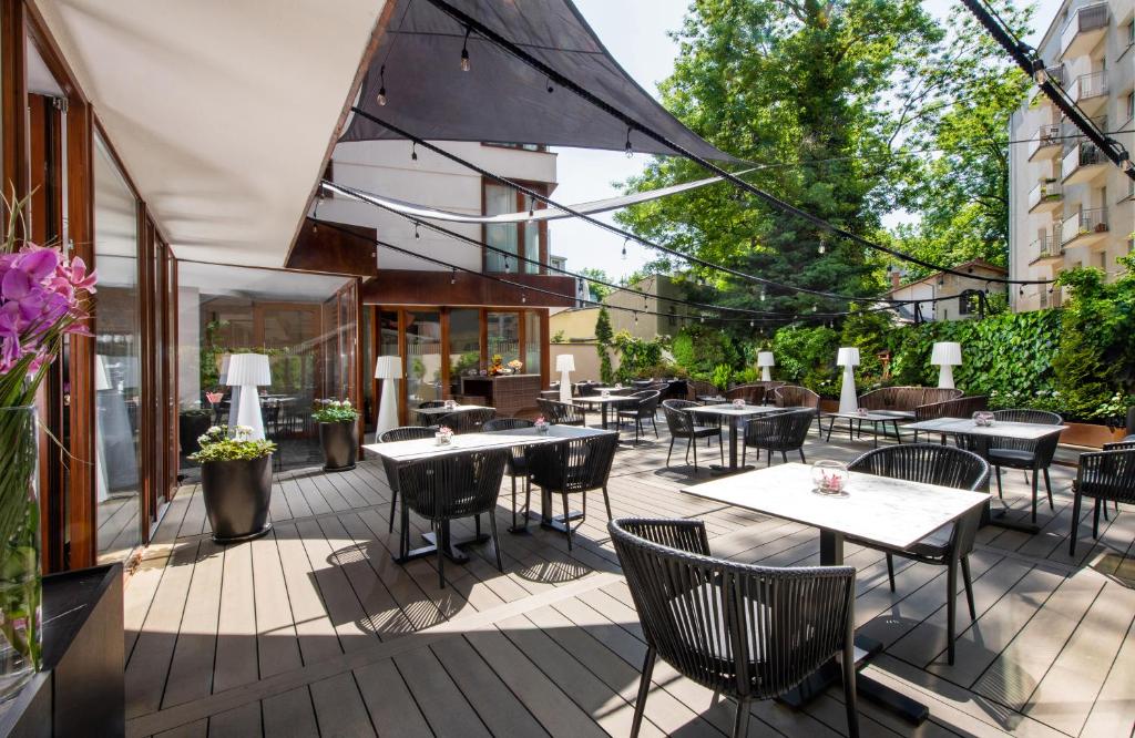 een patio met tafels en stoelen in een gebouw bij Leonardo Boutique Hotel Krakow City Center in Krakau