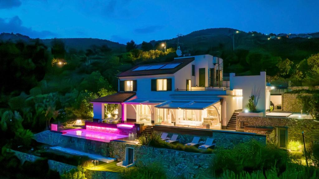 une maison avec une piscine en face de celle-ci la nuit dans l'établissement VILLA VERETIUM 8, Emma Villas, à Borgio Verezzi