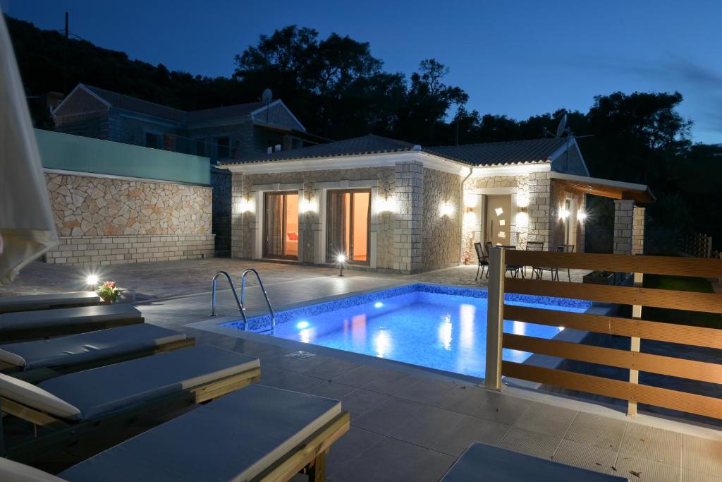 a swimming pool in front of a house at night at Villa Michalis in Liapades