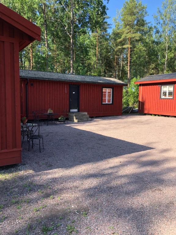 ein rotes Gebäude mit einem Picknicktisch davor in der Unterkunft Lillemyrsgården in Forshaga