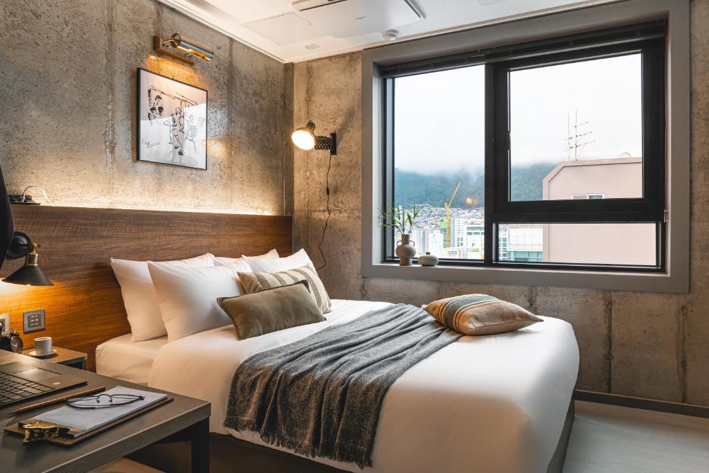 sypialnia z łóżkiem, biurkiem i oknem w obiekcie Urbanstay Boutique Nampo BIFF w Pusanie