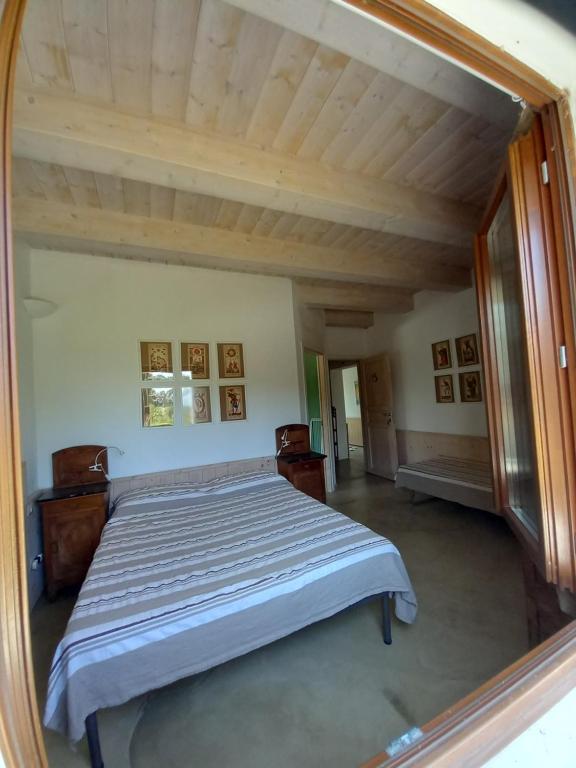 um reflexo de um quarto com uma cama num espelho em Casa Rosa em San Costanzo