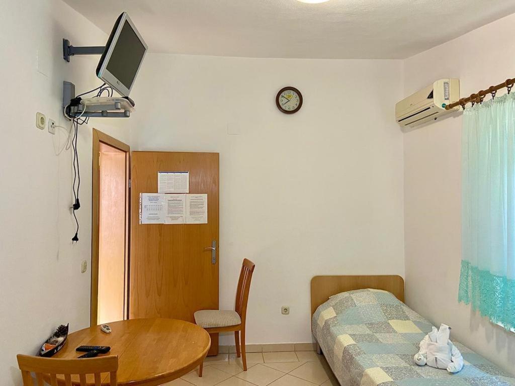 een slaapkamer met een bed en een tafel en een bed en een bureau bij Apartments Tiho & Jelena in Blace
