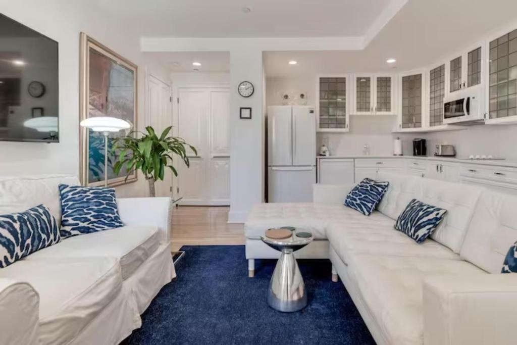 uma sala de estar com sofás brancos e um tapete azul em Tropicals of Palm Beach em Palm Beach