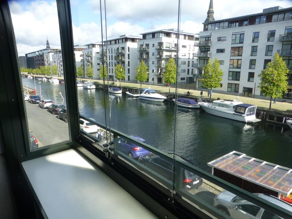 uma vista a partir de uma janela de um rio com barcos em Christianshavn Apartments 536 em Copenhaga
