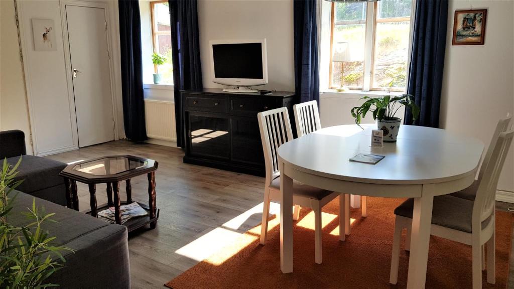 uma sala de estar com uma mesa e uma televisão em Parkvillan Sunshine Living Condo em Koppom